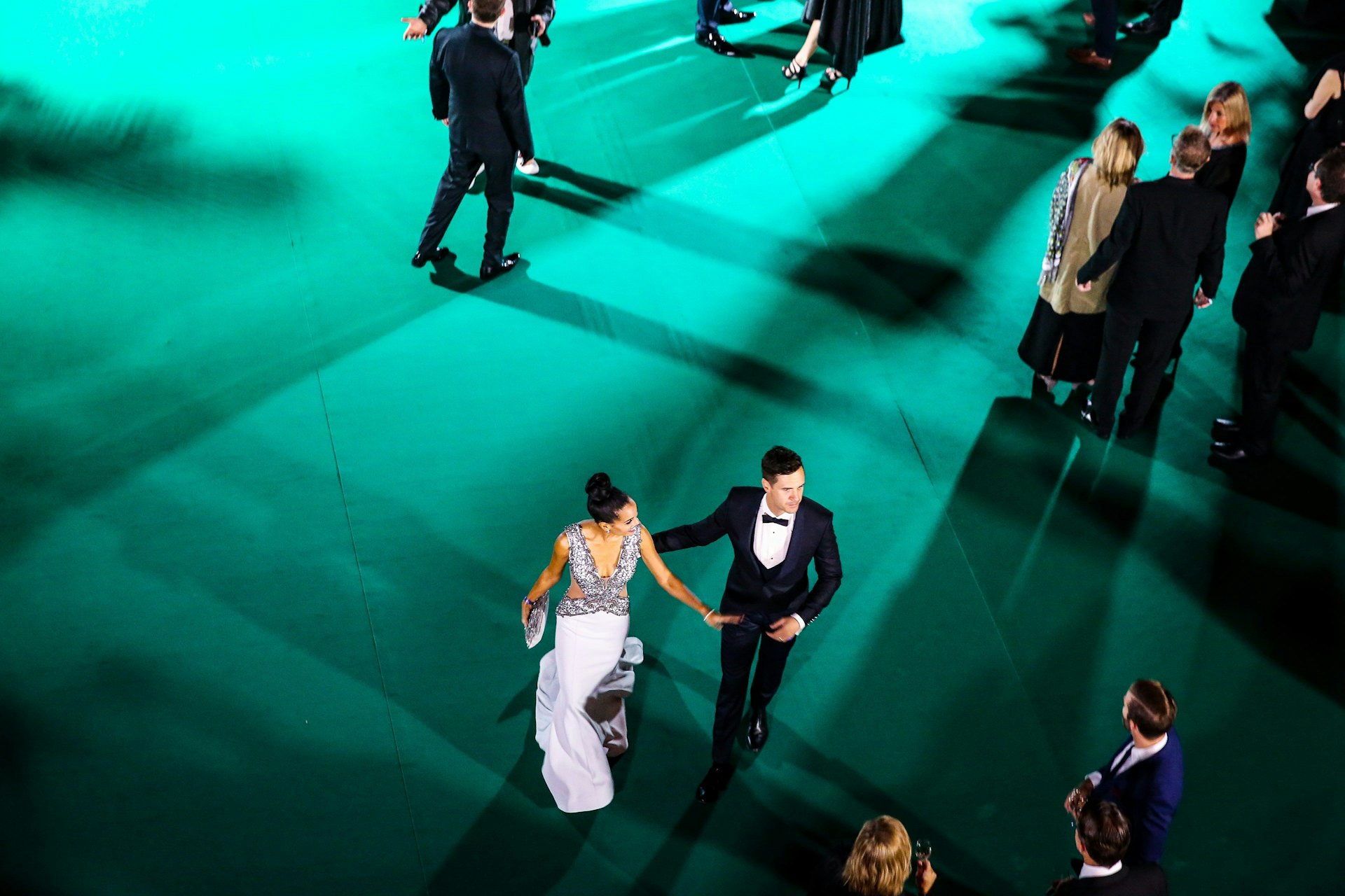 Zwei ZFF Gäste, einen Mann und eine Frau, die über den Grünen Teppich laufen.